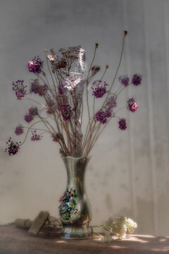 Still life with delicate dried flowers. Vintage vase with flowers. Bouquet of flowers in a vase. Garlic seed florets.