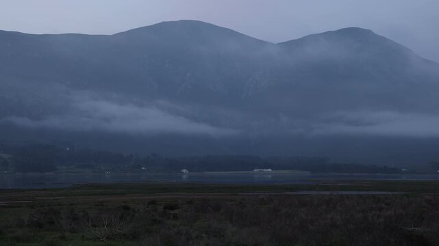 delicate fog hovering below Klein Mountains and lagoon and country road, Stanford, South Africa