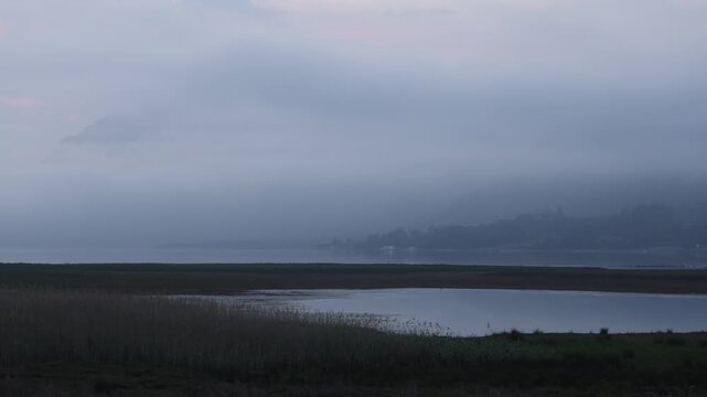 delicate fog hovering below Klein Mountains and lagoon and country road, Stanford, South Africa