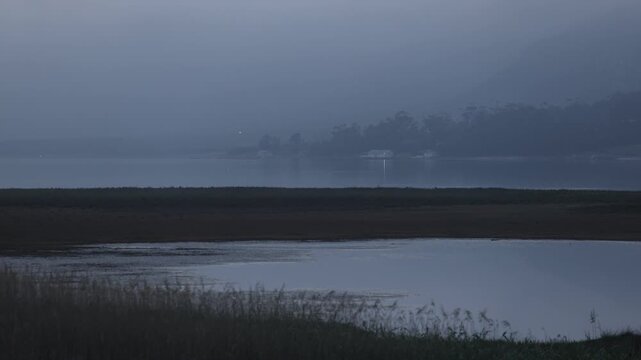 delicate fog hovering below Klein Mountains and lagoon and country road, Stanford, South Africa