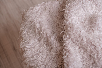 Soft fluffy white textile texture close up on wooden floor © Alena Vilgelm