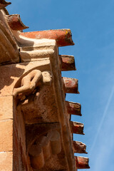 Carved stone corbel depicting a human figure under the eaves of the 12th century Romanesque church of Nuestra Senora de la Asuncion, located in Jaramillo de la Fuente, Burgos, Castilla y Leon, Spain © Nandi Estévez