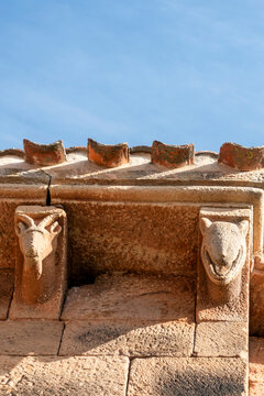 Carved stone corbels displaying animal heads of a ram and a beast under the eaves of the 12th century Romanesque apse of Nuestra Senora de la Asuncion church, located in Jaramillo de la Fuente, Burgos
