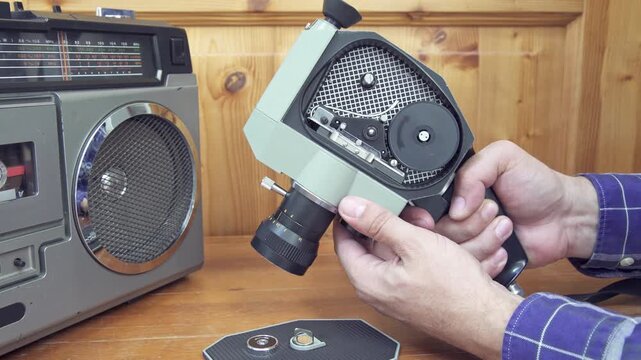 Testing film transport and reel mechanism on vintage 8mm movie camera with boom box. retro aesthetic concept