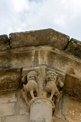 Naklejka premium Transition Romanesque-Gothic carved stone capital depicting winged lions on the exterior apse of the Church of Nuestra Senora de la Asuncion in Tuesta, Alava, Basque Country, Espana