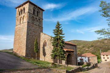Fototapeta premium Collegiate Church of San Pedro with its bell tower and portal, 12th century Romanesque architecture, Cervatos, Campoo de Enmedio, Cantabria, Spain