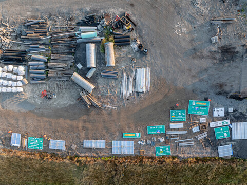 Aerial view of construction materials, various road signs, and industrial pipes stored at the Interurban South Trailhead in Fife, Washington, United States.