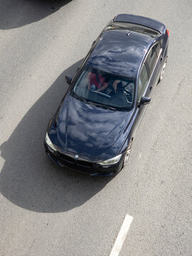Top view of a BMW premium sedan driving through city traffic illustrating modern transportation and executive automotive design