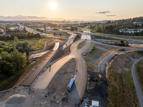 Aerial view of the Interurban South Trailhead construction site, featuring new road infrastructure and paved paths under the golden hour light in Fife, Washington, United States.