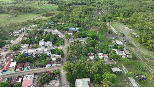 Aerial view of the town of Sabana de la Mar featuring residential houses, lush palm trees, and dense vegetation. Sabana de la Mar, Hato Mayor Province, Dominican Republic.