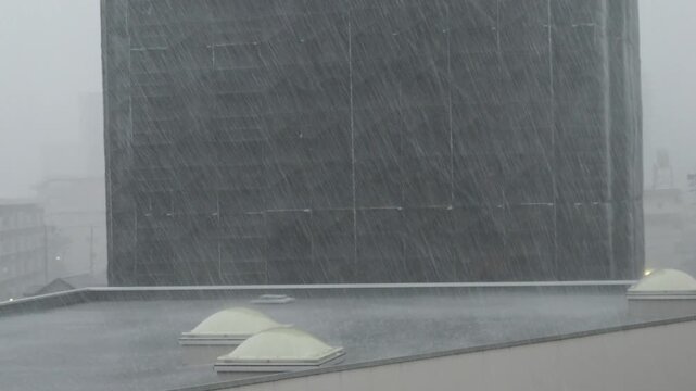 夏のゲリラ雷雨の様子と都市の住宅地のメンテナンス中のマンションの様子