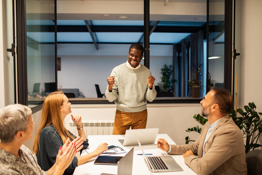 Diverse business team celebrating success in modern office