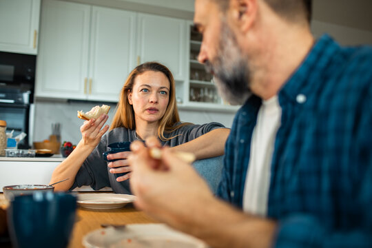 Couple having serious conversation over breakfast in home kitchen