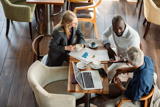 Diverse business team meeting over coffee in cafe