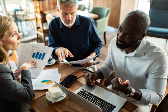 Coworkers discussing financial report at coffee shop
