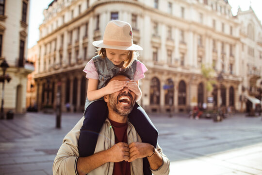 Father and daughter playing on city street