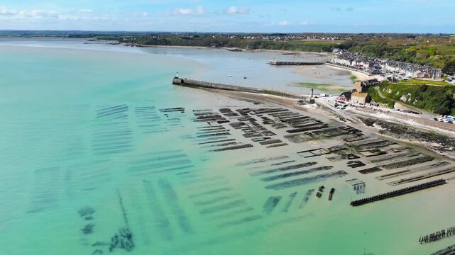 Aerial shot of oyster beds at low tide on the French coast, featuring exposed shellfish cultivation areas in shallow water