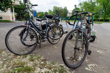 Fototapeta premium Several bicycles and electric scooters parked together. These modes of transportation are used for active travel on campuses and in cities. E-scooters, rental option in cities. To rent and park. 