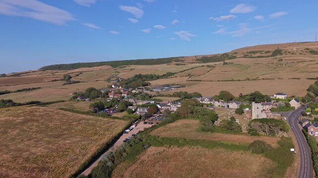 Aerial drone footage of Chale village on the Isle of Wight, England, showcasing the rural village, surrounding countryside, and rolling landscape in warm evening light