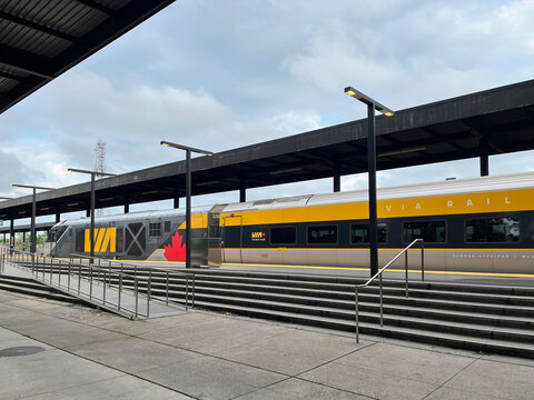 VIA Rail passenger train stopped at Ottawa station platform with stair and ramp