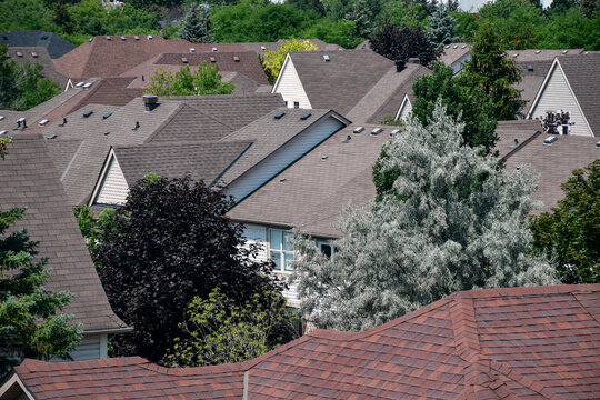 High angle view showing residential neighborhood with brown and gray shingled roofs