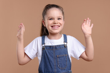 Portrait of happy little girl on brown background © New Africa