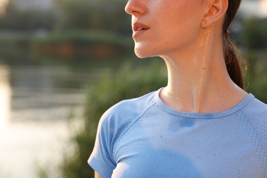 Young woman with sweat on her body outdoors, closeup. Space for text