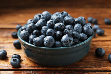 Fresh ripe blueberries in bowl on wooden table, closeup © New Africa