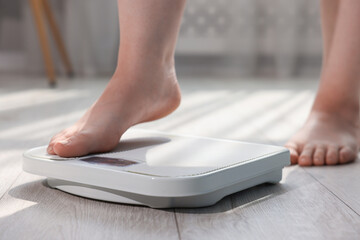 Fototapeta premium Overweight woman on scale at home, closeup