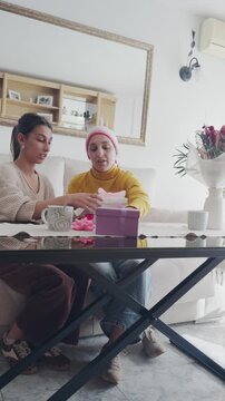 Daughter supporting mother with cancer during celebration at home