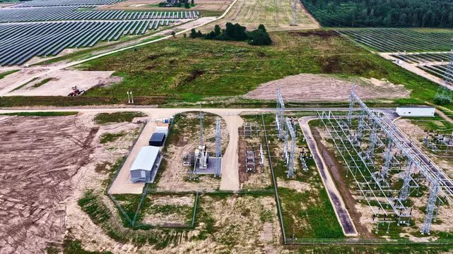 Aerial view of solar farm and electrical substation with rows of solar panels and power infrastructure in Tume, Tukums Municipality, Latvia.