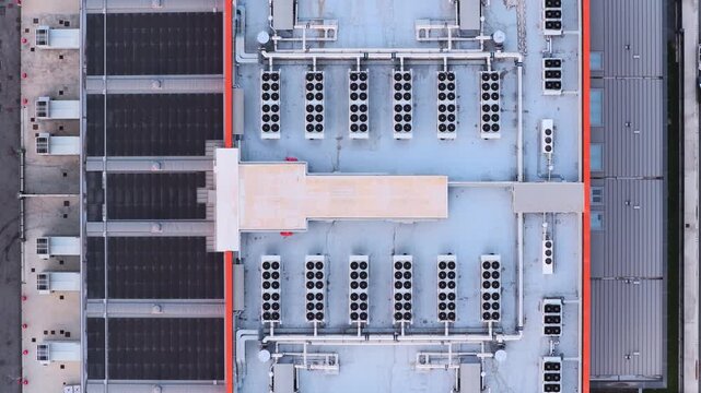 Aerial view of a datacenter rooftop with rows of industrial HVAC cooling units and ventilation systems in Rome, Lazio, Italy.