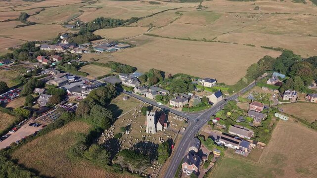 Aerial drone footage of Chale village on the Isle of Wight, England, showcasing the rural village, surrounding countryside, and rolling landscape in warm evening light