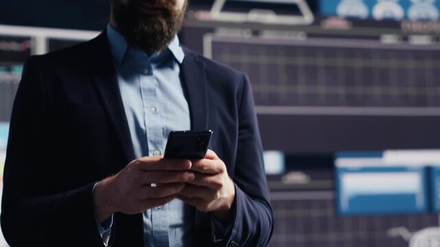 Entrepreneur sends a text message while reviewing analytics reports, using mobile communication, performance data and management insight to support business development.