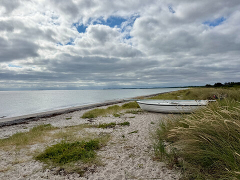 Sailboat on an unspoiled sandy beach on an overcast summer day, Nordby, Samsoe, Jutland, Denmark