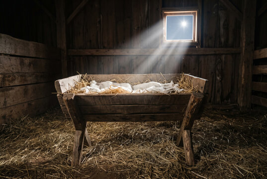 Empty wooden manger with straw illuminated by starlight in dark barn