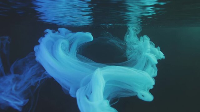 blue tint ink swirling in water with dark background