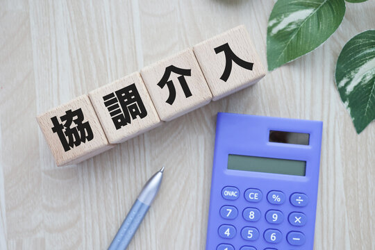 為替の協調介入。木製ブロック。電卓と観葉植物。ビジネスイメージ。