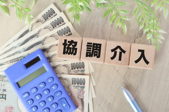 為替の協調介入。木製ブロック。電卓と観葉植物。ビジネスイメージ。