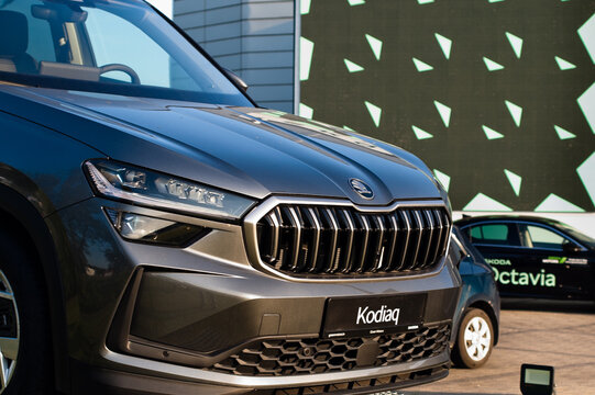 Riga, Latvia - July 30, 2026: A new Skoda Kodiaq car on the street near a car dealership with an advertising billboard in the background