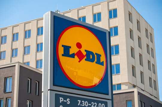 Riga, Latvia - April 29, 2026: A close-up of a billboard with the Lidl store logo, with a gray building and blue sky in the background