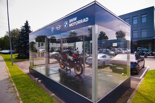 Riga, Latvia - July 15, 2026: This photo shows a new BMW motorcycle behind a glass display case outside a car dealership