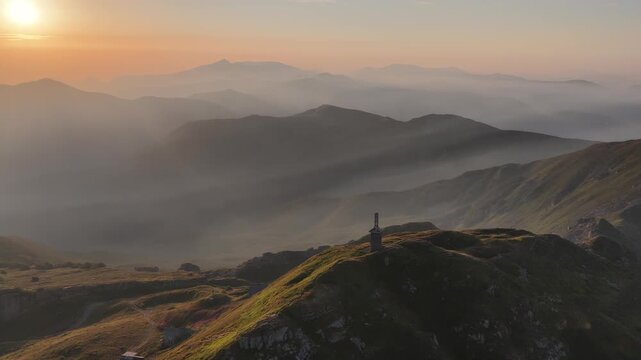 Aerial view of the monument on the mountain peak at sunset in Cerreto Laghi, Emilia-Romagna, Italy.