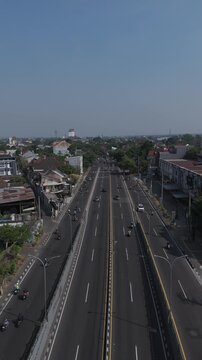 Aerial view of Underpass Kentungan with traffic on the road surrounded by urban buildings and trees in Kecamatan Depok, Daerah Istimewa Yogya, Indonesia.