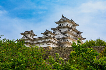 Naklejka premium The historic white Himeji Castle complex against a blue sky in Hyogo, Japan