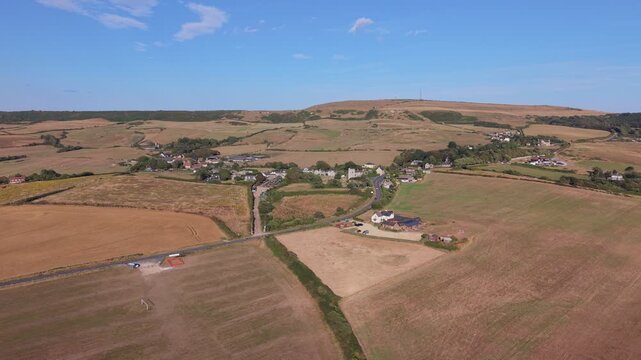 Aerial drone footage of Chale village on the Isle of Wight, England, showcasing the rural village, surrounding countryside, and rolling landscape in warm evening light