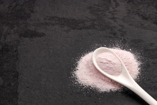Resveratrol powder supplement with a fine texture and a spoon, associated with wellness and health.