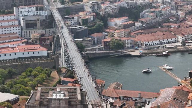 Aerial view of the iconic Luis I Bridge spanning the Douro River with historic buildings and boats in Porto, Porto District, Portugal.