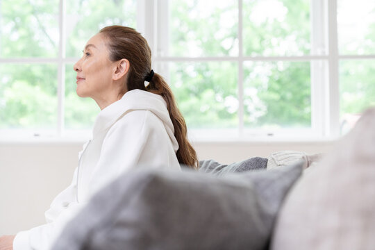 部屋でリラックスするシニア女性