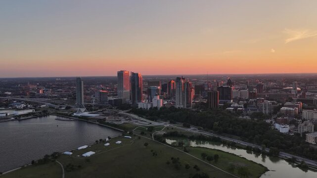 Aerial View of Milwaukee Skyline at Dusk with Lakefront Park and Lagoon&rdquo; Aerial view of downtown Milwaukee, Wisconsin at dusk, with skyscrapers catching pink sunset light above a lakefront park, lagoo